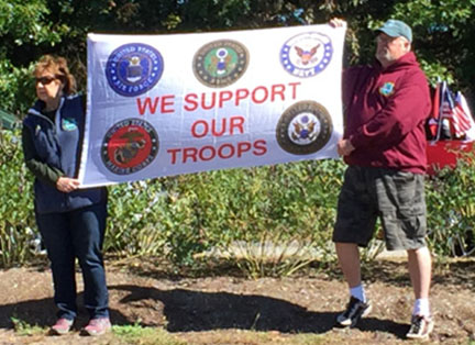 Members Holding a 'We Support Our Troops' Sign